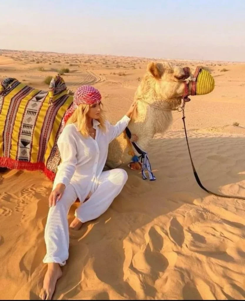 Tourists enjoying a camel ride during a Dubai desert safari