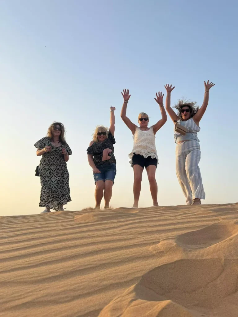 Family enjoying and playing together in the golden sand during a Dubai desert safari